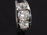 a close up of a diamond ring on a black surface
