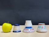three vases and an apple sitting on a table