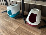 two litter boxes sitting next to each other on the floor