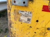 a close up of a yellow post with a sticker on it