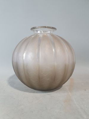 un vase en verre posé sur une table, sur fond blanc