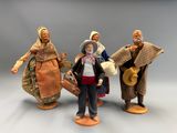 trois figurines représentant des personnes vêtues de costumes traditionnels et coiffées de chapeaux traditionnels