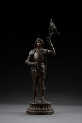 a bronze figure of a knight holding a flag and a sword