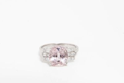 une bague sertie d'un saphir rose et de diamants sur fond blanc