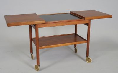 a small wooden table with a glass top on wheels