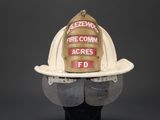 fireman ' s helmet with visor and goggles on display against a gray background