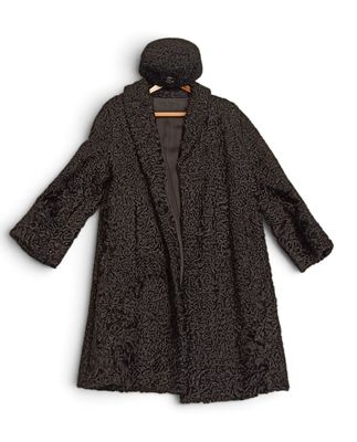 un manteau de femme avec une capuche et un chapeau, suspendu à un cintre