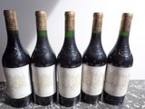 six bouteilles de vin sont alignées sur une table