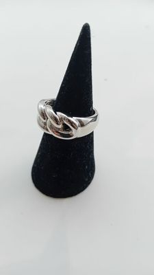 un gros plan d'une bague en argent posée sur un cône noir