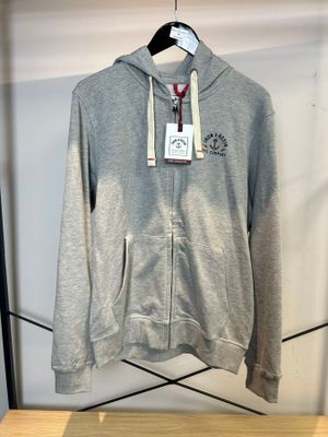 un sweat à capuche gris accroché à un portant dans un magasin de vêtements