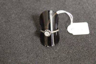 a silver ring with a diamond on it sitting on a table