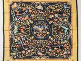 a black and yellow silk scarf with a floral design