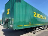 un camion-benne vert garé sur le parking