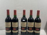 four bottles of wine are lined up on a counter