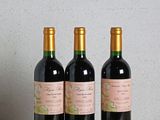 trois bouteilles de vin posées sur une table en bois