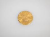 a gold coin sitting on top of a white surface
