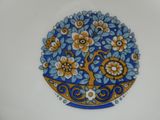 une assiette bleue et jaune sur laquelle est représenté un arbre