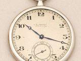 a silver pocket watch with roman numerals on the face