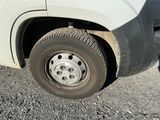 a white truck with a flat tire parked in a parking lot