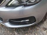 the front end of a car with a denting dent on it ' s bumper