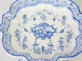 a blue and white plate with a picture of people and animals on it