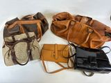 several purses are lined up on a white surface, including one brown and one black