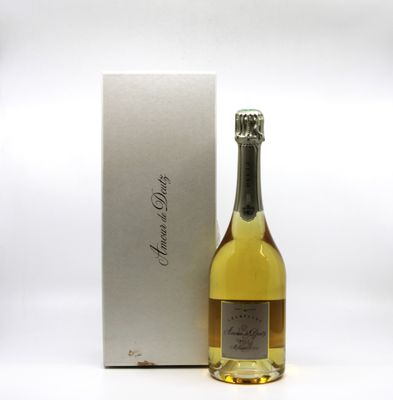 bottle of champagne in front of a white box with a silver lid