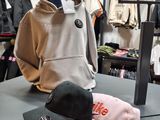 several hats and jackets are on a table in a clothing store