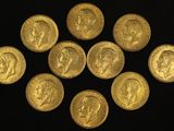 a close up of a bunch of gold coins on a black surface