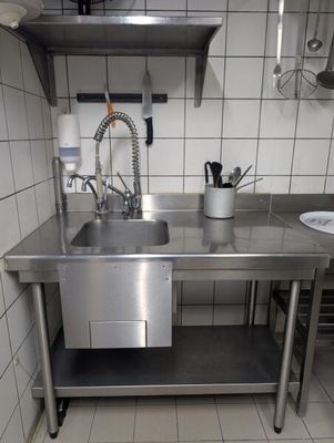 un évier en acier inoxydable dans une cuisine, à côté d'un plan de travail