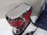 a red coffee maker sitting on a counter next to a blue box