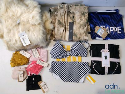 beaucoup de vêtements et un sac posés sur une table