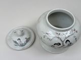 a white vase with a lid sitting on a table