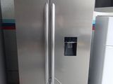 a stainless steel refrigerator with a black top in a kitchen