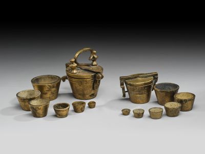 un ensemble d'objets en laiton, comprenant une bouilloire, des tasses et d'autres objets