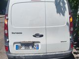 the back end of a white van parked on the side of a road