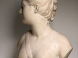 a white marble bust of a woman wearing a dress