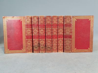 six livres rouges alignés en rangées sur une surface blanche