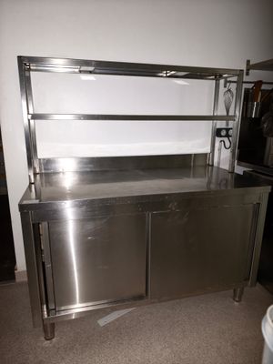 un plan de travail en inox dans une cuisine équipée d'une poubelle