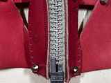 a close up of a red purse with a zipper on it