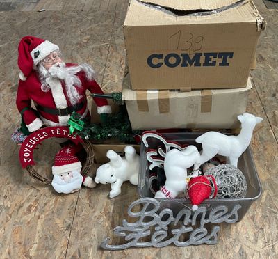 un Père Noël assis dans une boîte remplie de jouets
