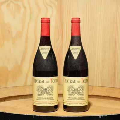 two bottles of wine sitting on top of a barrel