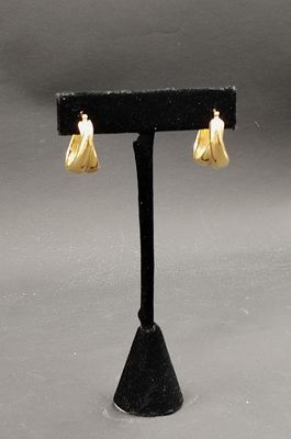 boucles d'oreilles plaquées or ornées de perles blanches sur un support noir