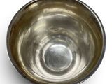 a silver bowl on a white surface with a white background