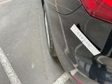 a sticker on the back of a car that is parked in a parking lot