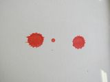 trois taches rouges à la surface d'une feuille de papier