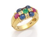 a gold ring with multi colored stones on a white background
