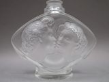 a glass bottle with a picture of a man and a woman inside of it