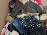 a cardboard box filled with clothes and a jacket
