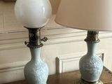 two lamps sitting on a table with a mirror in the background